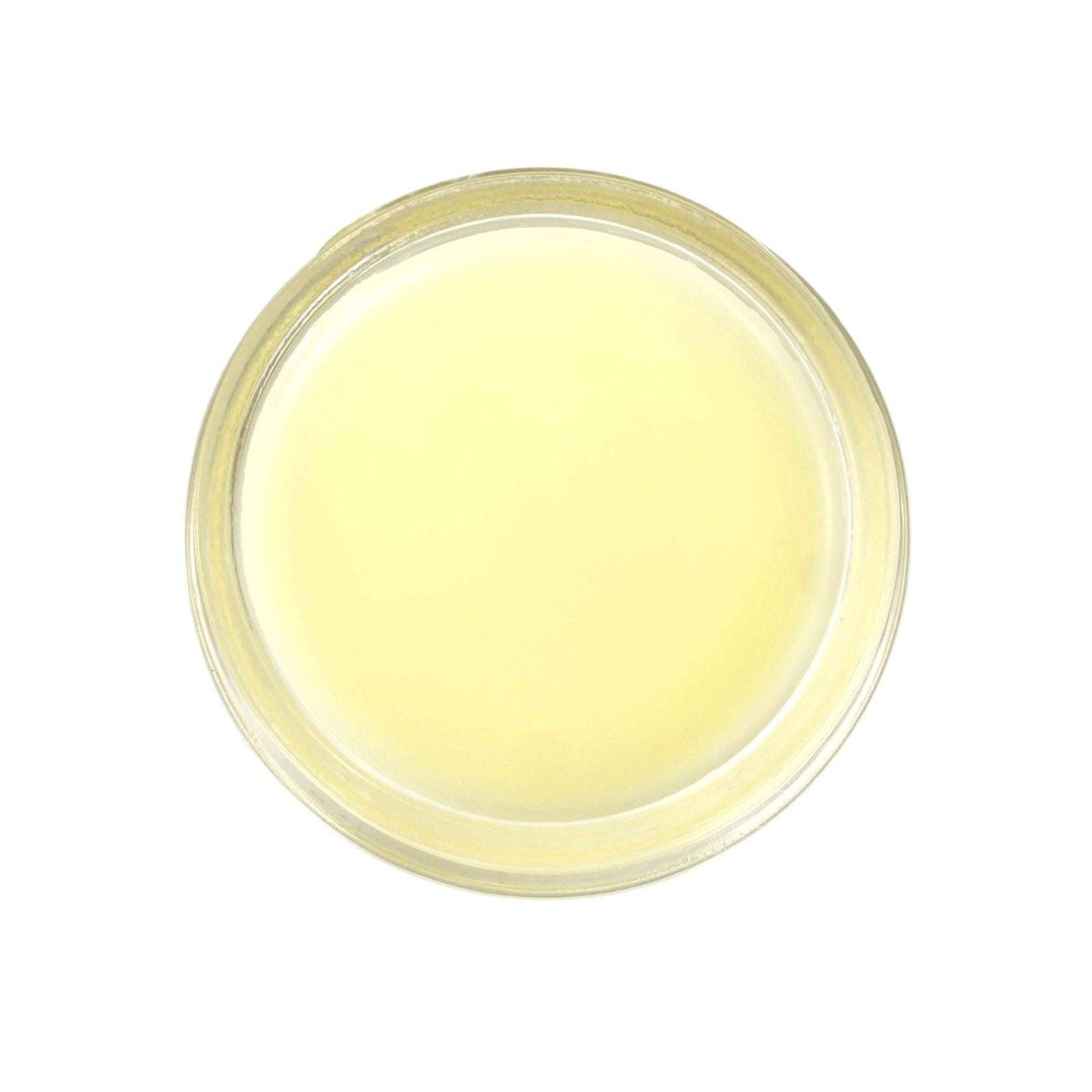 Round container of yellow nourishing and restorative balm on a white background