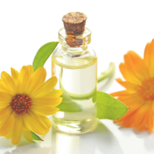 Small glass bottle with cork stopper on a white background with yellow flowers.