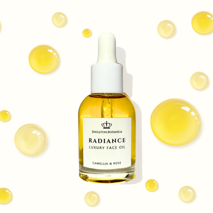 Radiance luxury face oil bottle with dropper on a white background with yellow droplets.